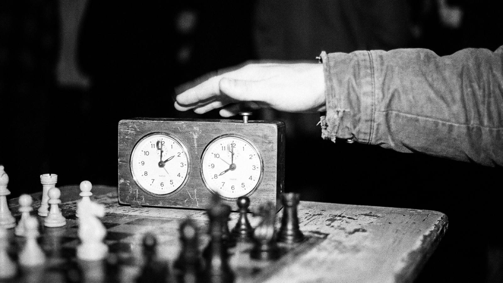 A hand slamming a chess clock
